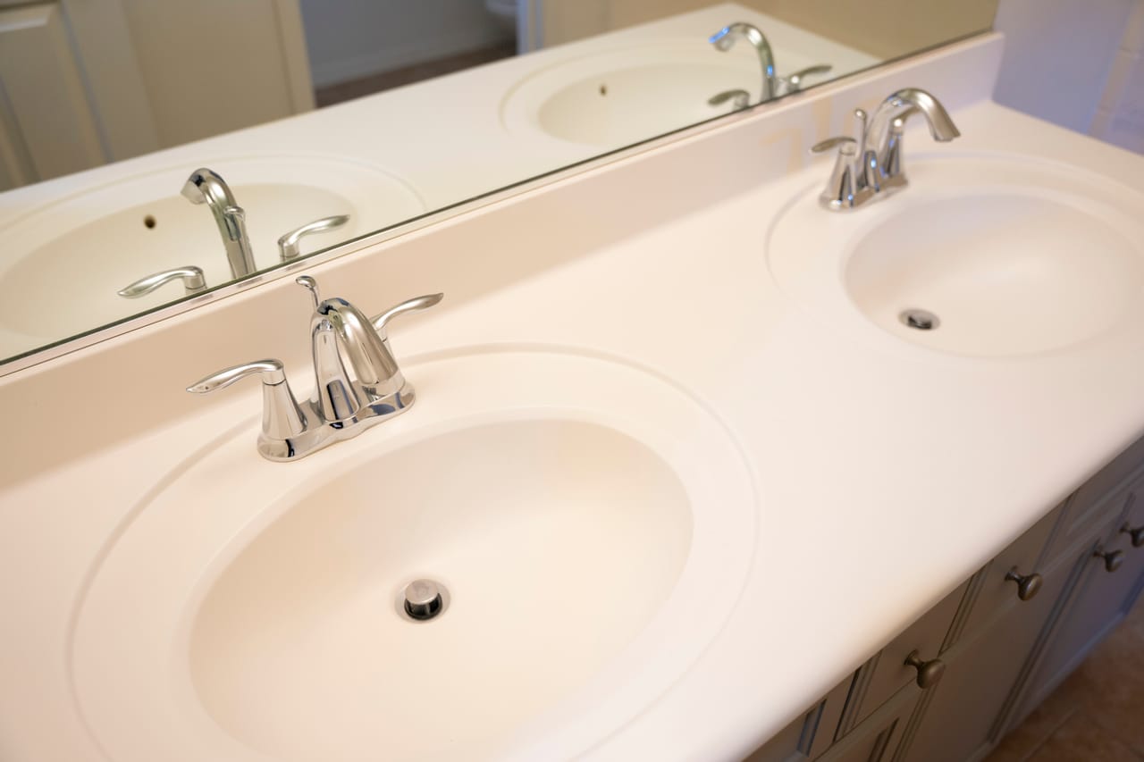 Double bathroom vanity with two refinished cultured marble sinks and chrome faucets